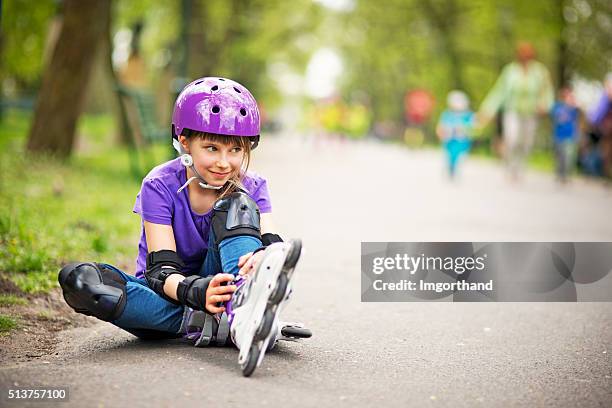 little girl rollerskating in park - rolschaatsen schaats stockfoto's en -beelden