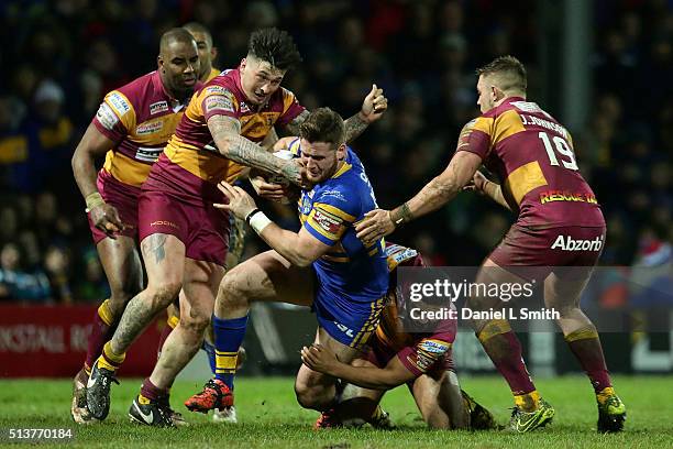 Anthony Mullally of Leeds Rhinos is tackled by Kruise Leeming and Oliver Roberts of Huddersfield Giants during the First Utility Super League match...