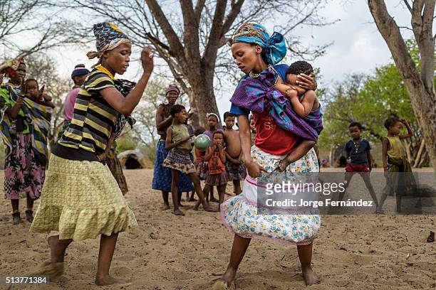 Group of people from the San tribe playing a game with a fruit called "monkey orange" in a remote village from the Kalahari desert.