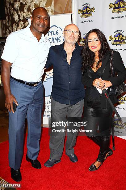 Evander Holyfield, Phil Collins, and Orianne Cevey pose for photos during Little Dreams Foundation Press Conference at LBar in Seminole Hard Rock...