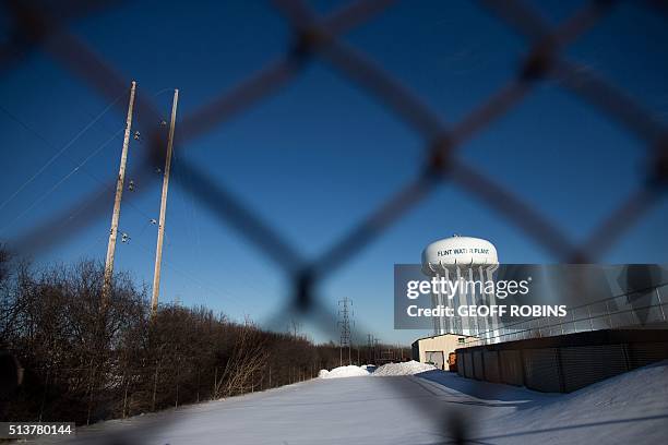 The water tower at the Flint Water Plant in Flint, Michigan, looms large over the city March 4, 2016 nearly 2 years after the start of the city's...