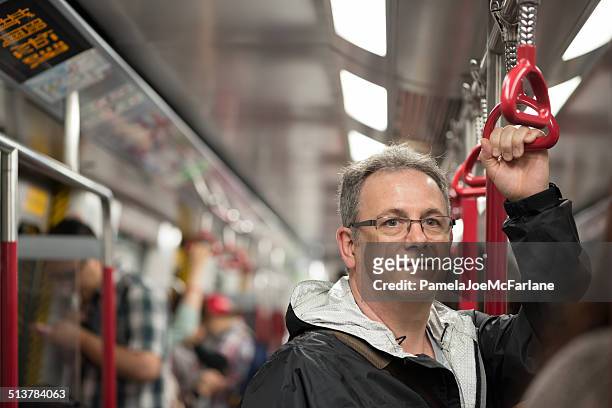 mature man riding train in hong kong - crowded train stock pictures, royalty-free photos & images