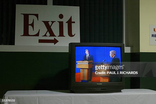 Democratic presidential candidate John Kerry and US President George W. Bush are seen on a television monitor inside the University of Miami in Coral...