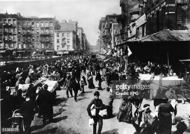 Bustling crowd of men and women shops among the market stalls on Hester Sreet, Lower East Side, New York, 1895.