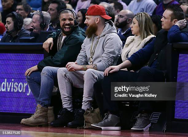 Rapper Drake smiles from his courtside seat during the first half of an NBA game between the Portland Trail Blazers and the Toronto Raptors at the...