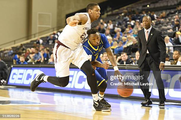 Kory Holden of the Delaware Fightin' Blue Hens dribbles by Nick Harris of the Charleston Cougars during the 1st round of the Colonial Athletic...