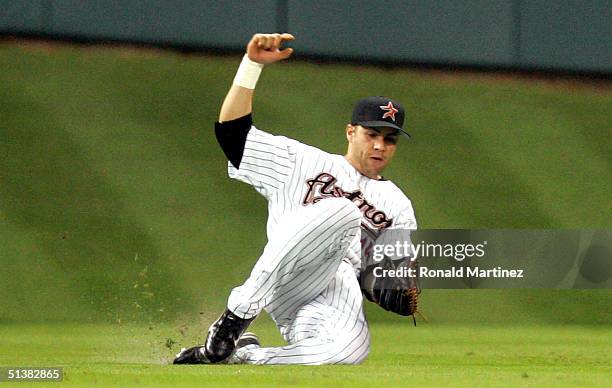 Center fielder Carlos Beltran of the Houston Astros slides to make the fly out on Garrett Atkins of the Colorado Rockies in the sixth inning October...