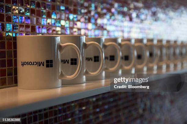 The logo of Microsoft Corp. Are displayed on cups in the pantry of the company's Office and Experience Center in Hong Kong, China, on Friday, March...