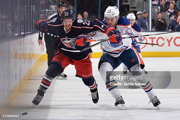 David Clarkson of the Columbus Blue Jackets and Leon Draisaitl of the Edmonton Oilers battle as they skate after a loose puck during the third period...