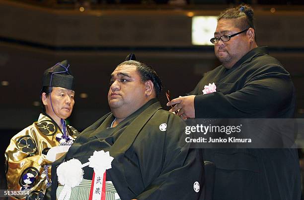 Japan's heaviest ever sumo wrestler, Hawaii-born Konishiki cuts a part of the topknot of the Hawaiian-born former grand champion, or yokozuna,...