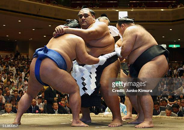 Hawaiian-born former grand champion, or yokozuna, Musashimaru gets his sumo loincloth during the topknot cutting ceremony on October 2, 2004 in...