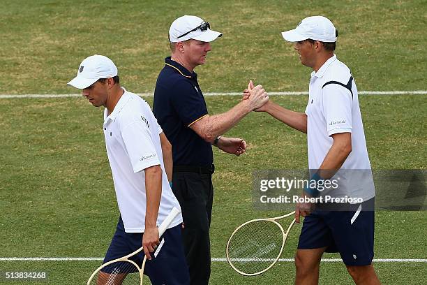 Jim Courier captain of the United States congratulates his players Bob Bryan of the United States and Mike Bryan of the United States after their win...