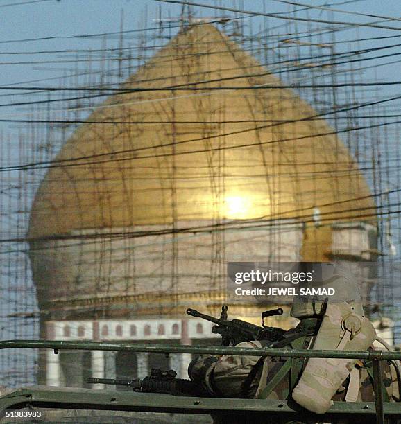 Soldier mans a machine gun mounted atop of a humvee as he patrols past the golden mosque of Imam Hassan al-Askari in Samarra, 02 October 2004. The...