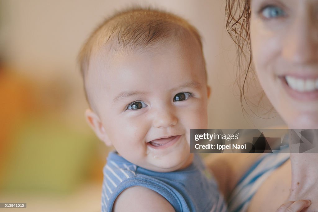 Baby smiling at camera with mother
