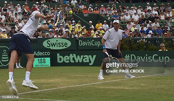 Mike Bryan watches as his brother Bob Bryan of the US plays a shot against Lleyton Hewitt and John Peers of Australia during the men's doubles match...