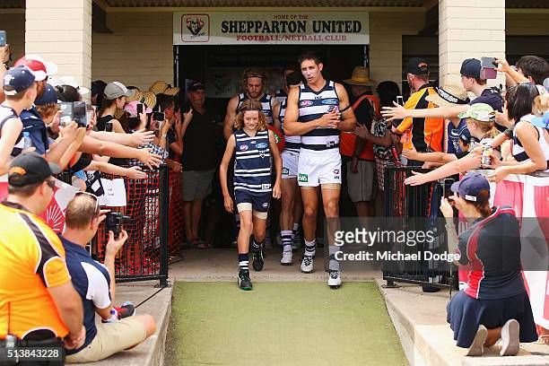 Harry Taylor of the Cats escorts the mascot onto the ground during the 2016 AFL NAB Challenge match between the Essendon Bombers and the Geelong Cats...