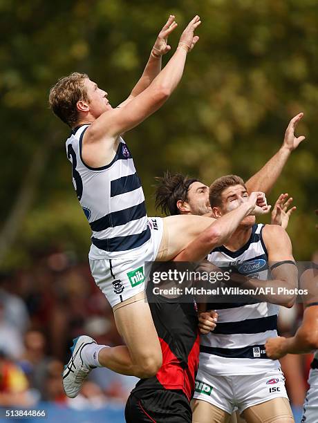 Josh Caddy of the Cats takes a spectacular mark over Mitch Brown of the Bombers during the 2016 NAB Challenge match between the Essendon Bombers and...