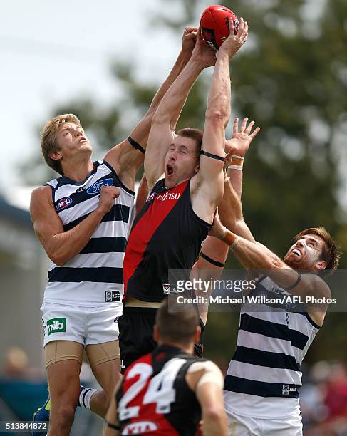 Shaun McKernan of the Bombers mark over Rhys Stanley and Tom Lonergan of the Cats during the 2016 NAB Challenge match between the Essendon Bombers...