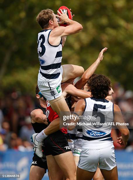 Josh Caddy of the Cats takes a spectacular mark over Mitch Brown of the Bombers during the 2016 NAB Challenge match between the Essendon Bombers and...