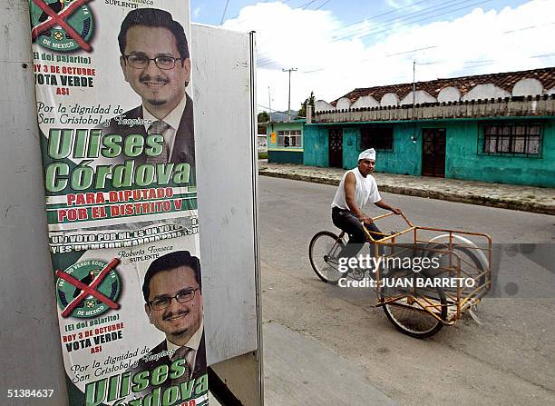 Un hombre pasa junto a un cartel del candidato municipal Ulises Cordova, del Partido Verde Ecologista de Mexico, en San Cristobal, al sureste de...