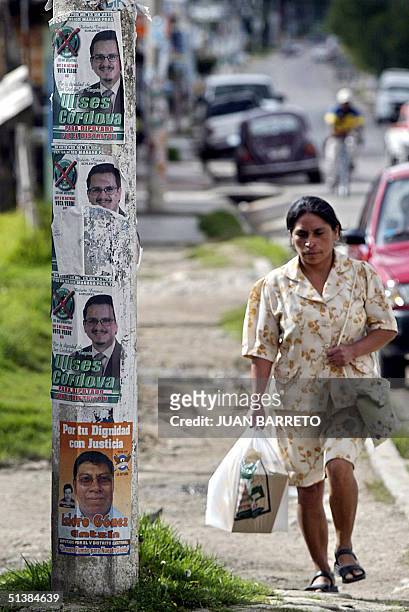 Una mujer pasa junto a carteles del candidato municipal Ulises Cordova, del Partido Verde Ecologista de Mexico, en San Cristobal, al sureste de...