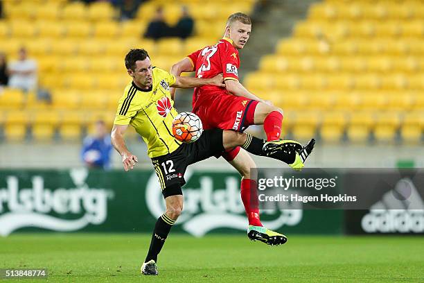 Jordan Elsey of Adelaide United and Blake Powell of the Phoenix compete for the ball during the round 22 A-League match between the Wellington...