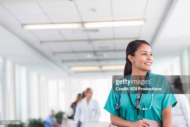 beautiful nurse gazing out window during shift at hospital - nurse huddle stock pictures, royalty-free photos & images