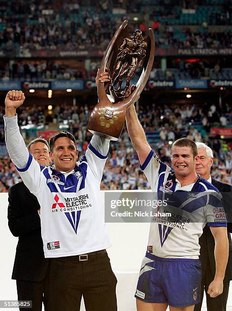 Injured captain Steve Price and stand in captain Andrew Ryan of the Bulldogs celebrate with the trophy during the NRL Grand Final between the Sydney...