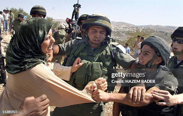 Palestinian woman scuffles with Israeli border policemen near the West Bank village of Beit Awwa, southwest of Hebron during a demonstration 03...