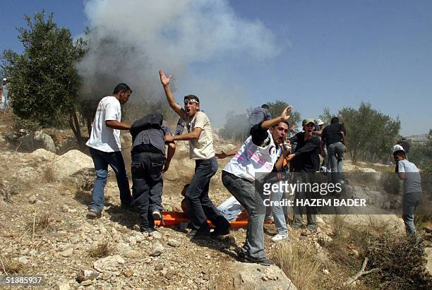 Palestinians shout to Israeli troops to stop shooting as they try to evacuate an injured man during clashes with Israeli border policemen near the...