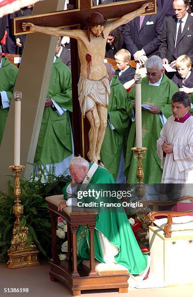 Pope John Paul II kneels as he prays during the beatification ceremony held in St. Peter's Square October 3 , 2004 in Vatican City. Pope John Paul II...