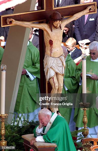 Pope John Paul II kneels as he prays during the beatification ceremony held in St. Peter's Square October 3 , 2004 in Vatican City. Pope John Paul II...