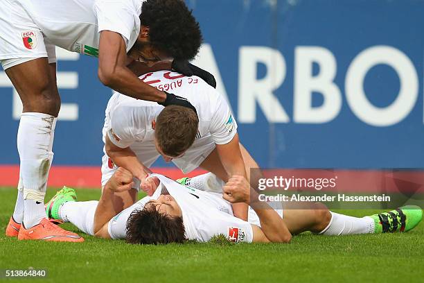 Ja-Cheol Koo of Augsburg celebrates scoring the third goal with his team mate Caiuby Francisco da Silva and Philipp Max during the Bundesliga match...