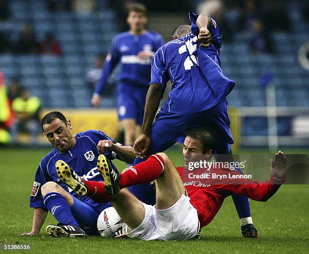 Eoin Jess of Nottingham Forest is tackled by Kevin Muscat and Marvin Elliot of Millwall during the Coca-Cola Championship League match between...