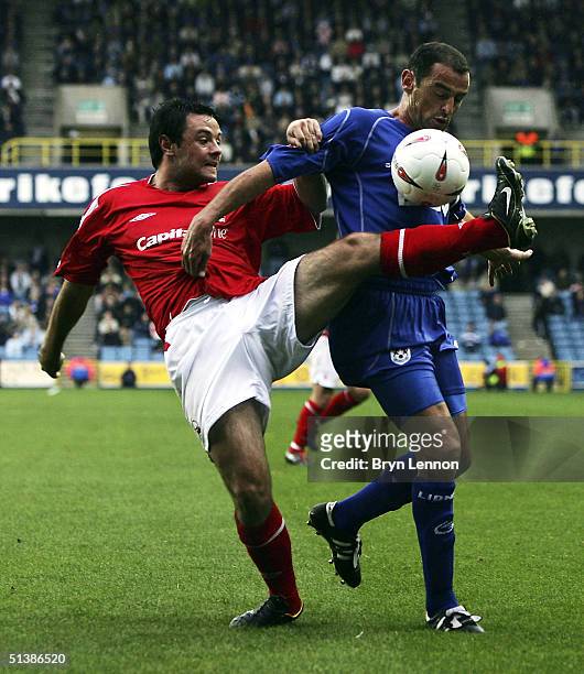 Kevin Muscat of Millwall holds back Andy Reid of Nottingham Forest during the Coca-Cola Championship League match between Millwall and Nottingham...