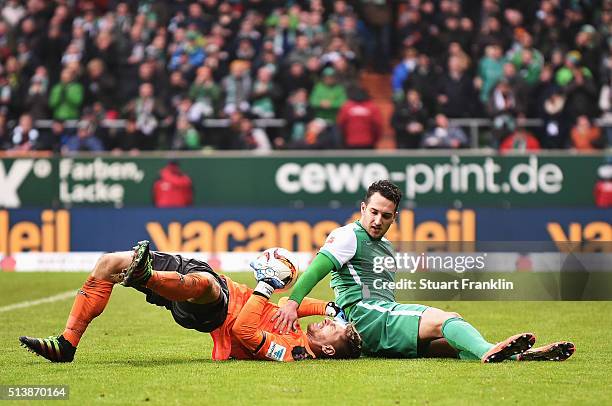 Levin ztunali of Bremen is challenged by Ron-Robert Zieler of Hannover during the Bundesliga match between Werder Bremen and Hannover 96 at...