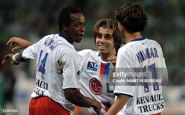 Saint-Etienne, FRANCE: Lyon's forward Sidney Govou is congratulated by his teammates Juninho and Nilmar of Brazil during their French L1 football...