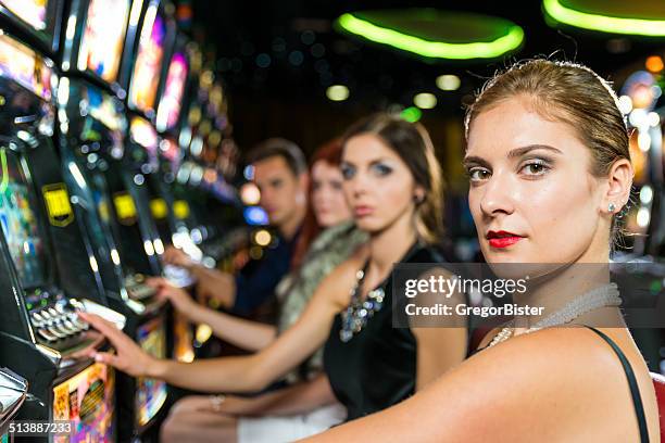 friends gambling in the casino on slot machines - teen pokies stock pictures, royalty-free photos & images