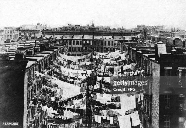 Photograph shows laundry drying on clotheslines in the backyards of New York City tenement slums, circa 1900.