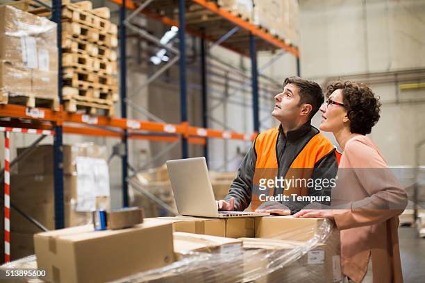 manager and worker doing a checklist in the warehouse. - warehouse stock pictures, royalty-free photos & images
