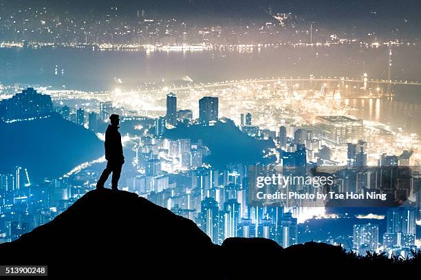 silhouette of standing hiker with hong kong city urban night view - ignorance photos et images de collection