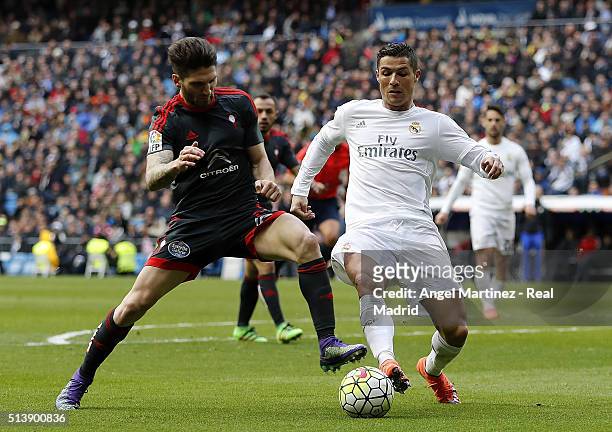Cristiano Ronaldo of Real Madrid competes for the ball with Carles Planas of Celta Vigo during the La Liga match between Real Madrid CF and Celta...