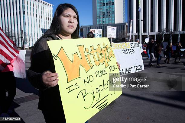 Anti-Trump protester stands outside the convention center where Republican presidential candidate Donald Trump made a speech at a campaign rally on...
