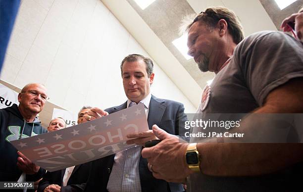 Republican presidential candidate Ted Cruz signs a poster at a campaign rally on March 5, 2016 in Wichita, Kansas The Republican party is holding its...