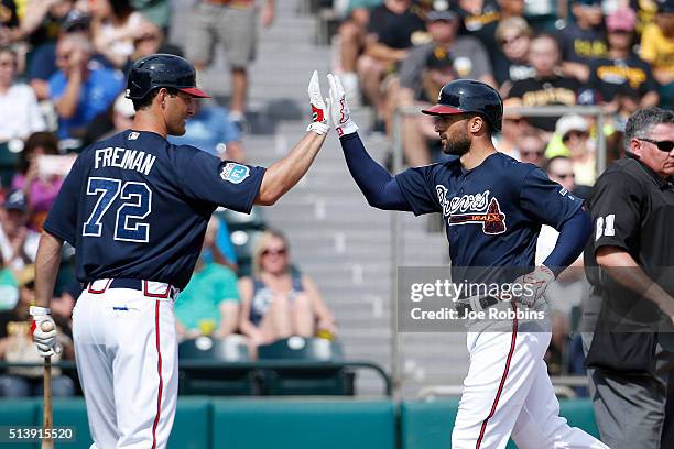 Nick Markakis of the Atlanta Braves is congratulated by Nate Freiman after hitting a home run in the fifth inning of a spring training game against...