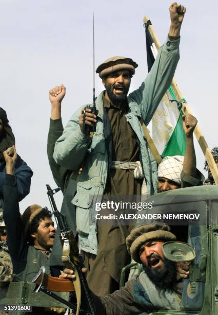 Northern Alliance soldiers shout 'Allah Akbar' and salute as they drive into Kabul, 13 November 2001, after they captured the Afghani capital....
