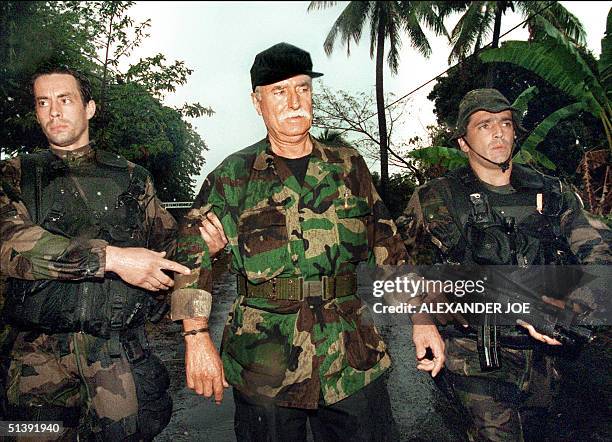 French veteran mercenary Bob Denard surrenders 05 October 1995 to French troops outside the army base in the Comoros. A French court ruled 04...