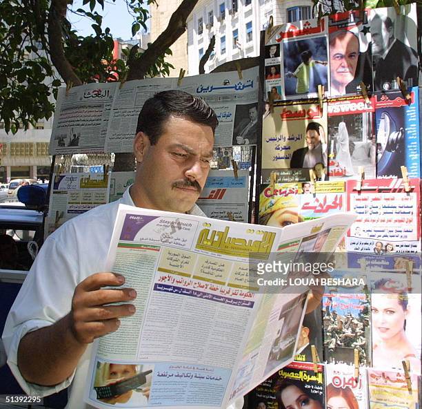 Syrian man reads 24 June 2001 in Damascus the first issue of "al-Iqtissidiya" weekly, the first Syrian economic journal not under state control....