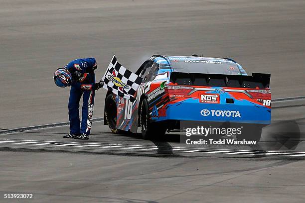 Kyle Busch, driver of the NOS Energy Drink Toyota, celebrates with the checkered flag after winning the NASCAR Xfinity Series Boyd Gaming 300 at Las...