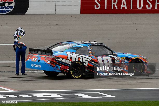 Kyle Busch, driver of the NOS Energy Drink Toyota, celebrates with the checkered flag after winning the NASCAR Xfinity Series Boyd Gaming 300 at Las...